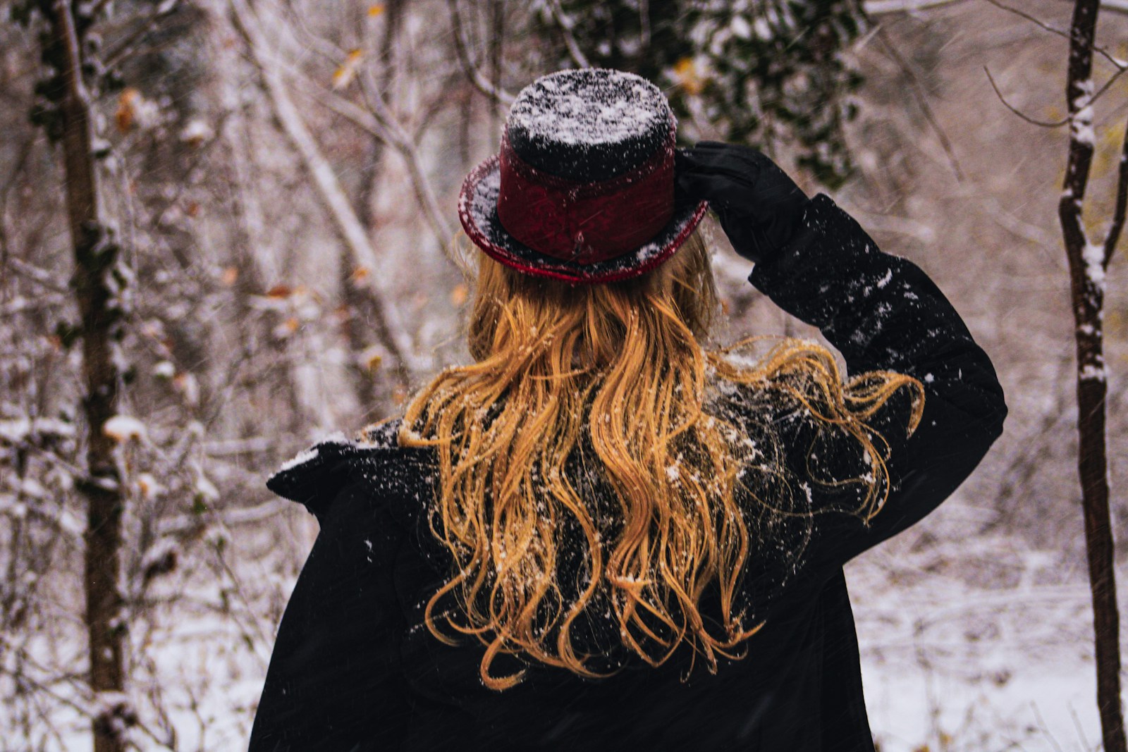 a woman standing in the snow with her back to the camera