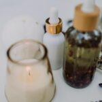 A calming spa setup featuring an aromatherapy candle, essential oils, and dried lavender for relaxation.